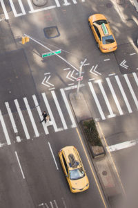 An areal shot of a bride and groom crossing the street in Manhattan with yellow cabs on the way to their wedding. Photo by Kelly Kollar Photography.
