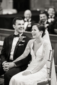 A bride and groom laugh during their wedding ceremony in Manhattan. Photo by Kelly Kollar Photography.