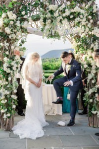A jewish couple breaks the glass under the chuppah at their wedding ceremony at The Garrison in New York. Photo by Kelly Kollar Photography.
