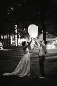 A bride and groom release an lantern on their wedding day at Camp Riverbend in New Jersey. Photo by Kelly Kollar Photography.