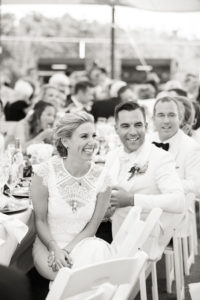 A bride and groom listen to speeches during their wedding reception at Cape May Beach Club in the Jersey Shore. Photo by Kelly Kollar Photography.