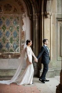 A bride and groom walk in Bethesda Terrace in Central Park in Manhattan on their wedding day. Photo by Kelly Kollar Photography.
