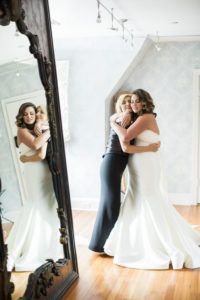 A bride hugs her mother before her wedding at Pleasantdale Chateau in New Jersey. Photo by Kelly Kollar Photography.