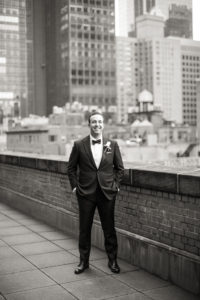 A groom waits on his wedding day on the balcony at New York Athletic Club in Manhattan. Photo by Kelly Kollar Photography.