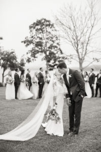 A bride and groom walk in front of their wedding party at Peconic Bay Yacht Club on The North Fork of Long Island. Photo by Kelly Kollar Photography.
