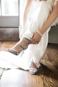 A bride adjusts her shoes before her wedding at Bedford Post Inn in New York. Photo by Kelly Kollar Photography.