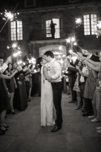 A bride and groom kiss with sparklers at the end of their wedding at Wainwright Club in Rye, New York. Photo by Kelly Kollar Photography.